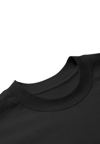 Detailní záběr na černý crewneck na krku a horní části hrudníku, ukazující podrobné šití a texturu látky.