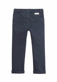 Tummansiniset farkut, suoranlahkeiset, joissa on kierretyt lahkeet, kaksi takataskua ja etiketti vyötärönauhassa.