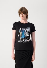 Black cotton t-shirt featuring a graphic print of two women and a dog, showcasing detailed illustrations in blue and white. Short sleeves, fitted design.