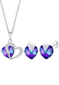 Lilla hjerteformet vedhæng og øreringe med klare accenter, sat i sølvfarvet metal. Funklende krystal detaljer forbedrer designet.