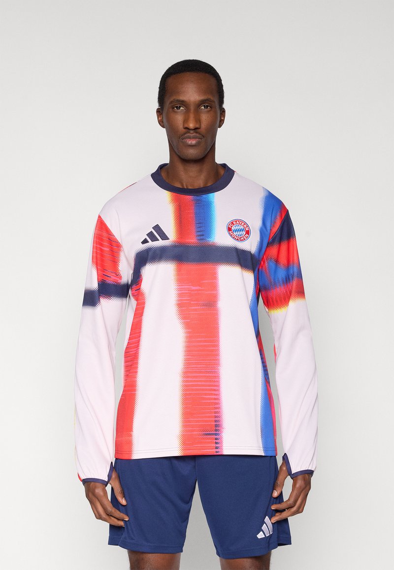 Rausva ilgomis rankovėmis futbolo marškinėliai su įvairiaspalvėmis vertikaliomis juostelėmis. Ant krūtinės yra „Adidas“ logotipas ir „Bayern“ Miuncheno emblema.