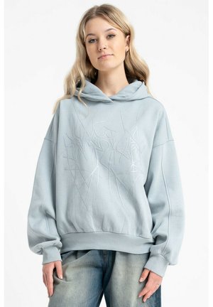 Jasnoniebieska, oversize bluza z kapturem wykonana z miękkiego materiału, z teksturowanym, abstrakcyjnym wzorem oraz sznurkiem przy kapturze. Długie, szerokie rękawy oraz prążkowany dół.