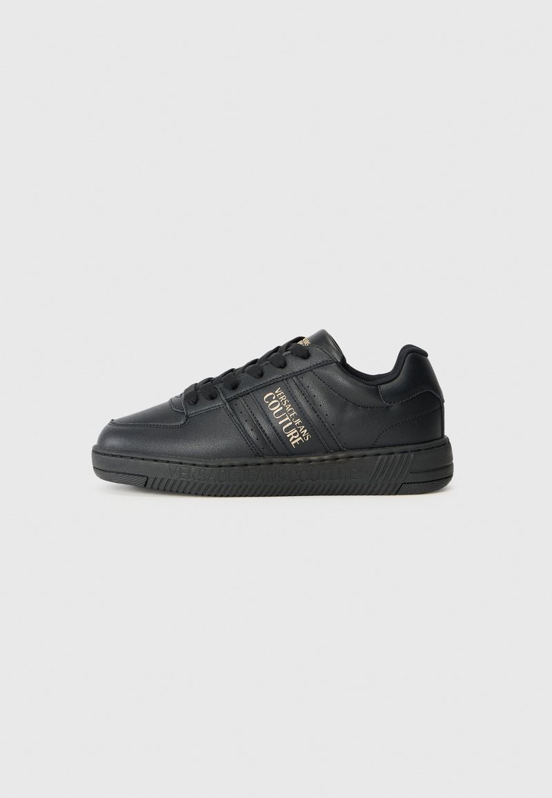 Baskets en cuir noir avec une finition texturée, dotées d'un détail de logo doré sur le côté et d'une semelle en caoutchouc conçue pour l'adhérence.