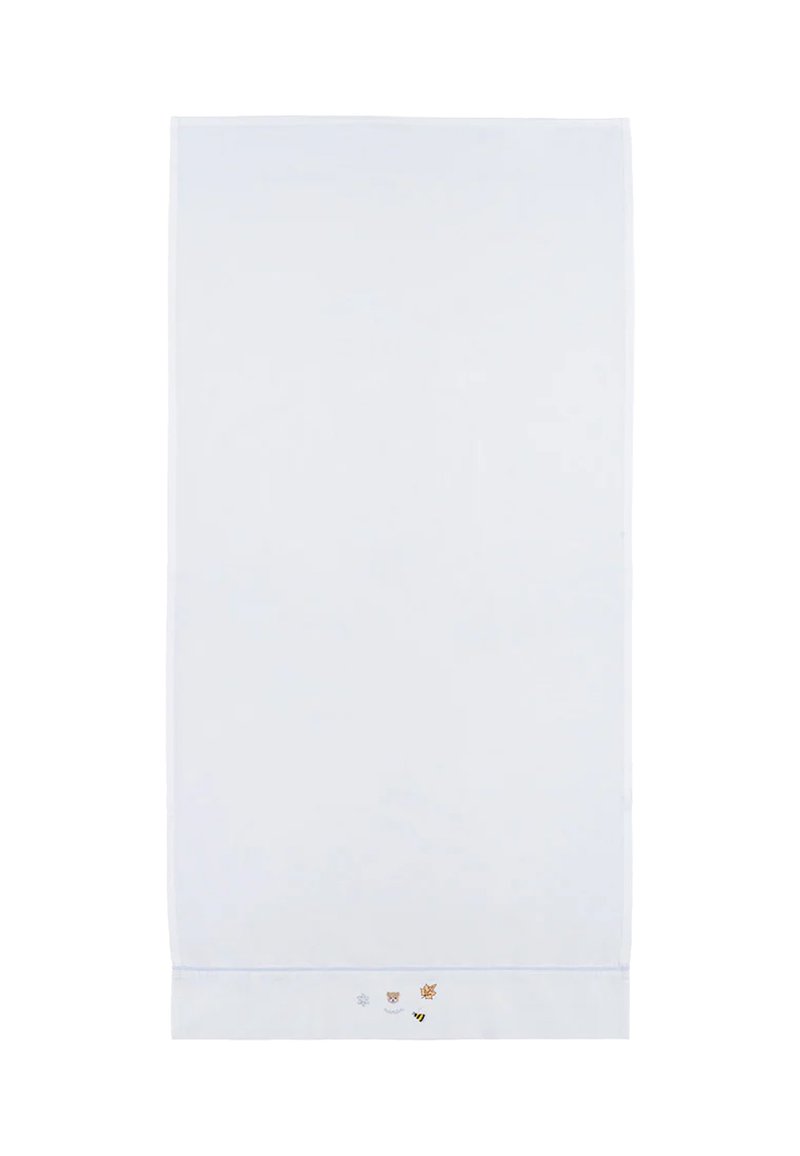 Biała tkanina koc o gładkiej fakturze, z małymi kolorowymi haftowanymi wzorami śnieżynki, niedźwiedzia, liścia i pszczoły na dolnej krawędzi.