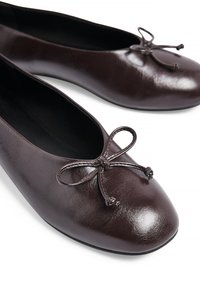 Hnedé kožené baletky s okrúhlym špičkou, so zdobením v tvare mašle na prednej strane. Hladká textúra a minimalistický dizajn.