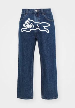 Jeans a gamba larga blu scuro con una grande grafica di un cane cartoon bianco sul taschino posteriore. Texture in denim, design tradizionale a cinque tasche.