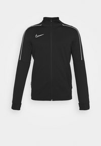 Black zip-up jacket with a high collar, featuring white side stripes and a small logo on the chest. Made of smooth fabric with fitted cuffs.