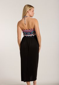 Trägerloses Maxikleid in Schwarz, mit einem bunten bestickten Oberteil mit geometrischen Mustern und einer Halspartie zum Binden. Glatter, fließender Stoff.