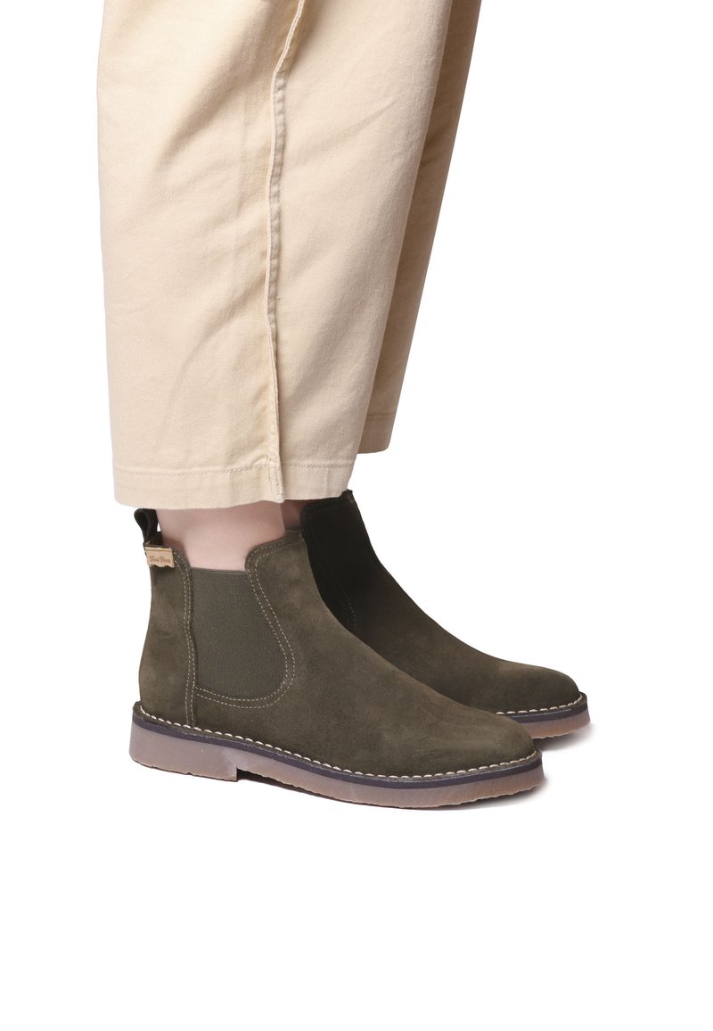 Olive green suede ankle boots with elastic side panels and a stitched rubber sole, featuring a pull tab at the back for easy wear.