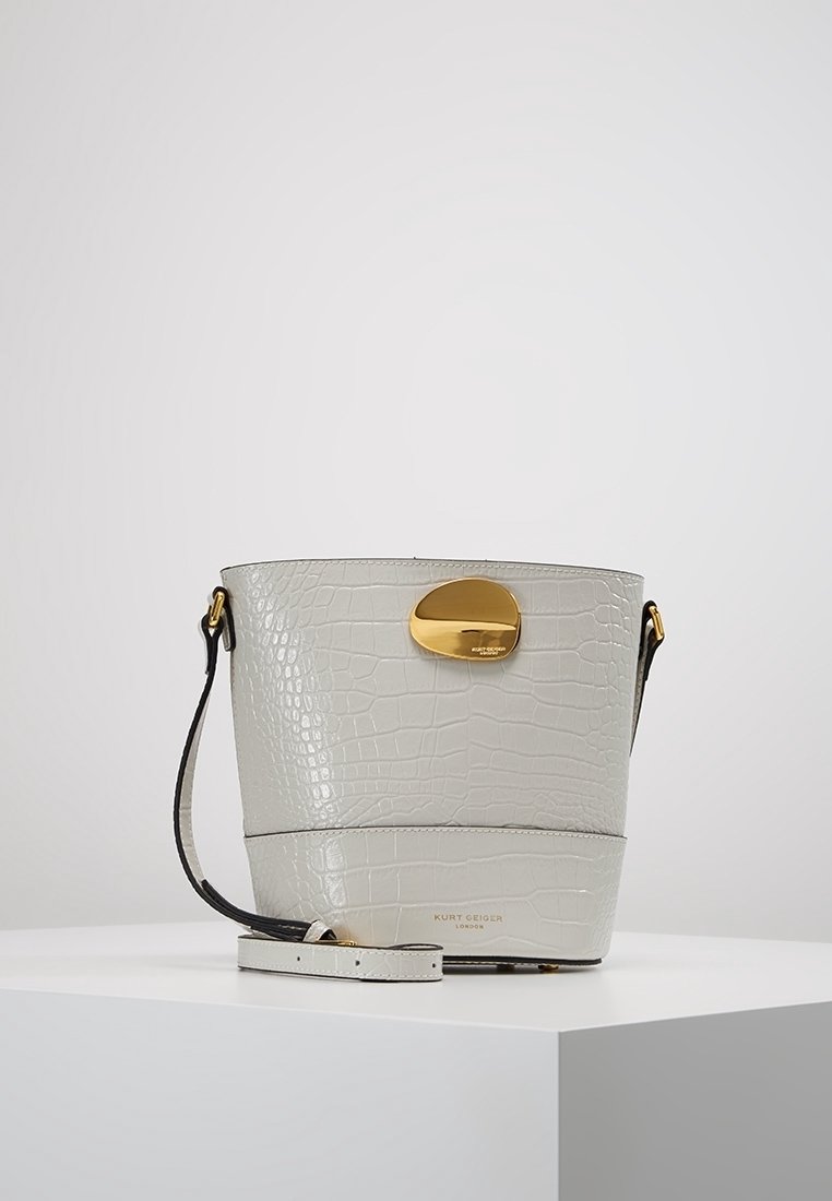 Borsa a secchiello in ecopelle goffrata coccodrillo grigio chiaro, con dettagli in metallo color oro, tracolla regolabile e texture liscia.