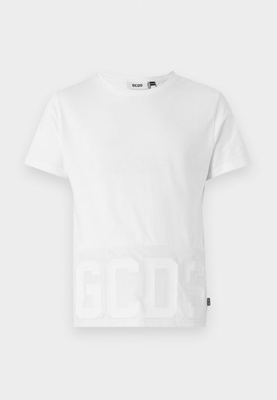 Maglietta bianca in cotone con collo rotondo, maniche corte e un pannello inferiore traslucido con il logo impresso "GCDS" in grandi lettere.