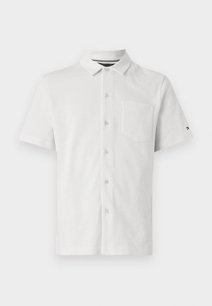 Short-sleeve white polo shirt featuring a button-up front, small pocket, textured fabric, and a subtle pattern.
