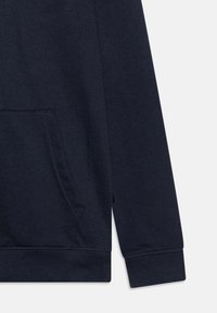 Sweatshirt bleu marine avec une poche kangourou, des poignets et un ourlet côtelés, en tissu doux et texturé, avec des détails brodés.
