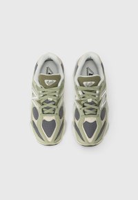 Sport sneakers med mesh og semsket skinn i nyanser av olivengrønn og grå, med hvite detaljer og en teksturert gummisåle.