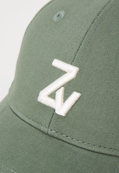 Cappellino da baseball verde con tessuto testurizzato, caratterizzato da un logo ricamato bianco. Include un bottone superiore e cuciture a punto.