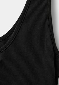 Čierny rebrovaný tielko s okrúhlym výstrihom a tenkými ramienkami, ktoré zobrazuje textúrovanú tkaninu s vertikálnymi pruhmi.