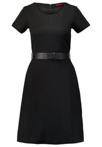 Robe noire texturée à manches courtes en ligne A, avec un col rond et une large ceinture noire à la taille.