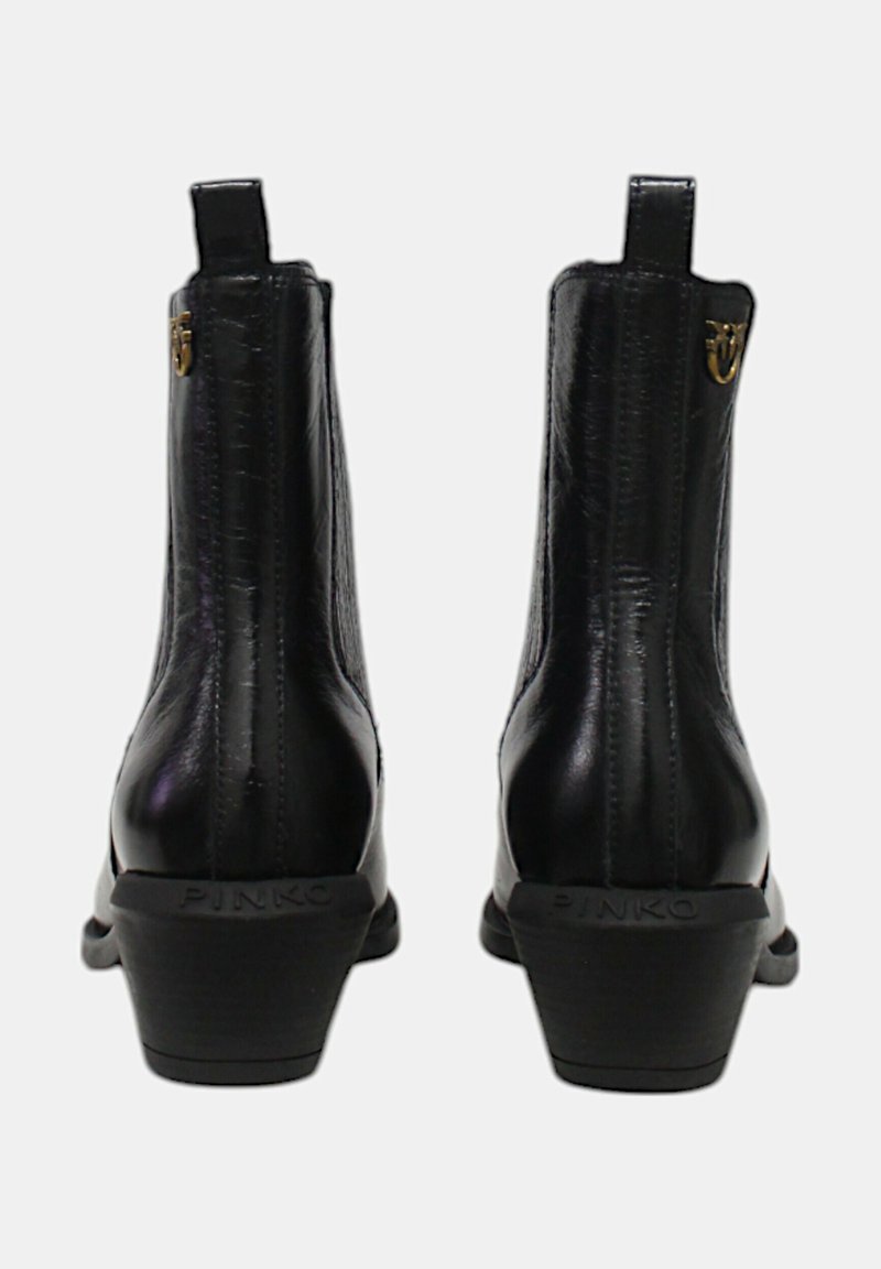 Czarne skórzane botki za kostkę o gładkiej fakturze, z niskim, zasuniętym obcasem oraz złotym akcentem logo z tyłu. Posiadają pętelki ułatwiające zakładanie.