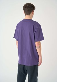 Lila Baumwoll-T-Shirt mit lockerer Passform, kurzen Ärmeln und rundem Halsausschnitt. Hat ein schlichtes Design ohne sichtbare Muster oder Grafiken.