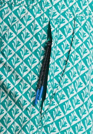 Türkiissinine kangas valge korallimustriga, küljes tasku musta tõmbluku ja siniste tõmblukukäepidemetega.