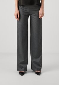 Pantaloni grigi a gamba larga realizzati in tessuto testurizzato, con vita alta, tasche frontali e una finitura liscia. Abbinati a décolleté nere a punta.