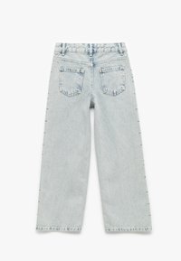 Lyseblå denim vid-leg jeans med en falmet finish, to baglommer og dekorative nitter langs de ydre sidesømme.