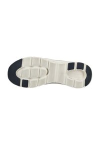 Semelle de chaussure avec base beige et patchs noirs antidérapants au talon, à l'orteil et au milieu du pied, avec des rainures texturées pour la traction.
