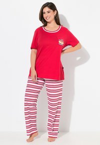 Rode katoenen t-shirt met een ronde halslijn en een zak; gecombineerd met gestreepte rode en witte pyjamabroek. Vlakke, gladde textuur.