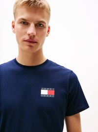 Námornícky modré bavlnené tričko s krátkymi rukávmi, s multikolórovým obdĺžnikovým logom na hrudi, ktoré obsahuje text "TOMMY" a "JEANS".