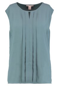 Haut sans manches bleu clair en tissu lisse avec des plis verticaux sur le devant et un col rond.