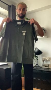 Tamsiai žalia polo marškinėliai su apykakle, ant kurių yra logotipas su užrašu "Yale." Pagaminti iš lygaus audinio, su trumpomis rankovėmis, demonstruojami asmens.