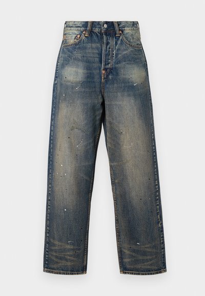 Pantalones vaqueros de mezclilla azul claro con un ajuste holgado, que presentan parches desgastados y salpicaduras de pintura blanca. Cierre de botón y diseño de cinco bolsillos.