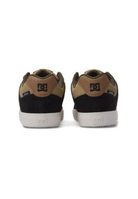 Vīriešu sporta apavi ar melnu zamšu un brūnu ādas akcentiem, gumijas zole, mīkstināta apkakle un logs uz papēža. Aizmugures skats parāda divtonētu dizainu.