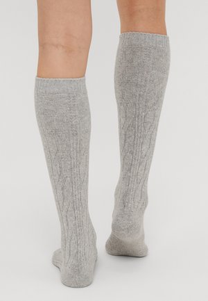 Meias cinzas até ao joelho com um padrão de malha texturizada, apresentando punhos canelados e um tecido macio e elástico para um uso confortável.