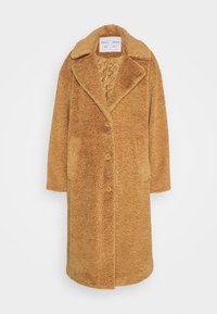 Lang, knopen-naar-boven jasje van fluffy, textuurstof in een warme karamelkleur. Heeft een geknipt kraag en zijzakken. Binnenvoering.