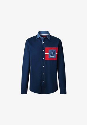 La camicia a maniche lunghe blu navy presenta un colletto in denim, una tasca a toppa rossa con logo e una striscia orizzontale bianca sul petto.