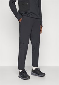 Melni sporta bikses ar konusveida dizainu, izgatavotas no viegla materiāla. Iekļauj rāvējslēdzēja kabatas un kontrastējošas šuves.