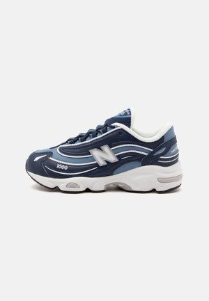 Baskets New Balance bleu marine avec détails blancs et bleu clair, semelle blanche épaisse, et marquage "1000" sur le côté.