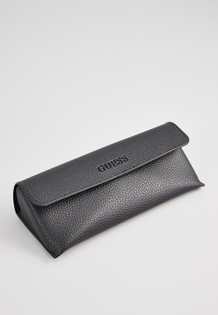 Custodia in pelle nera con una finitura testurizzata e chiusura a pattina, con logo "GUESS" in rilievo sulla parte frontale.