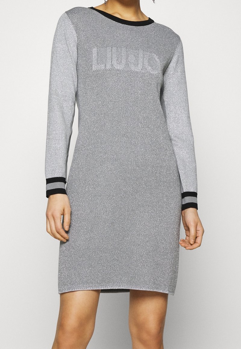 Graues Strickkleid mit langen Ärmeln, schwarzem geripptem Ausschnitt und kontrastierenden schwarz-grauen gestreiften Bündchen mit strukturiertem Finish.