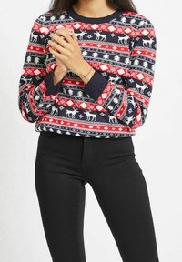 Röd, vit och blå mönstrad stickad tröja med renar och träd. Har lång ärm och rund halsutskärning; tillverkad av mjukt material.