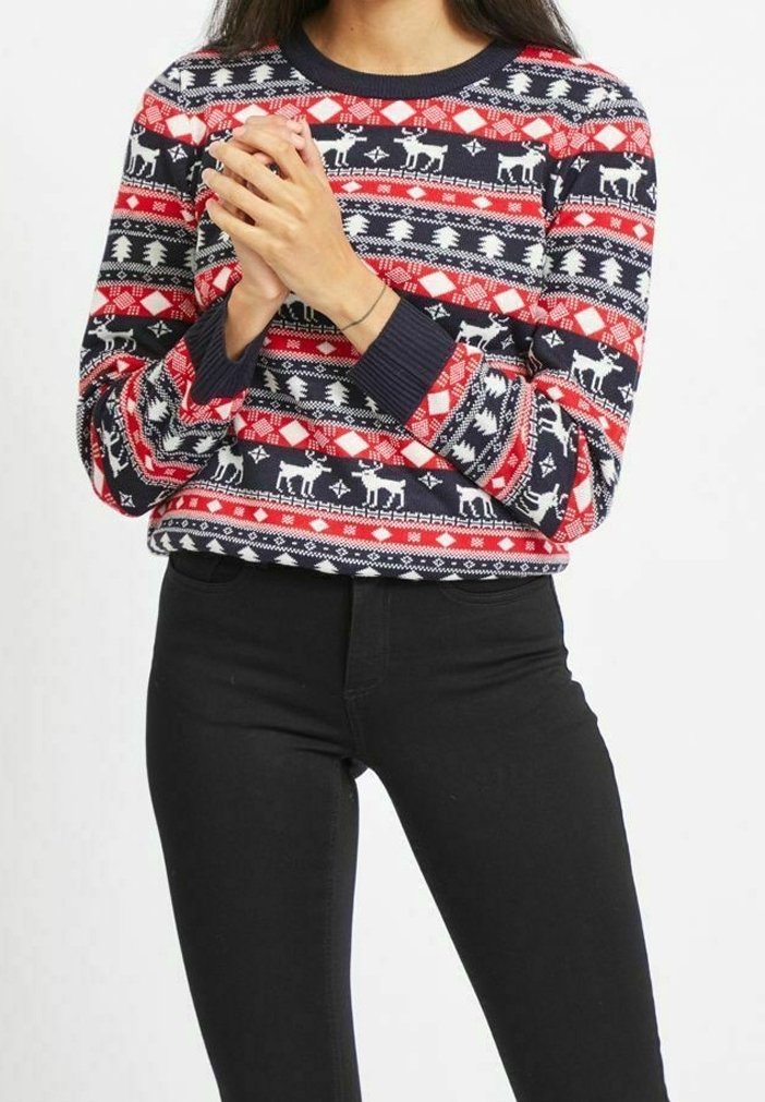 Röd, vit och blå mönstrad stickad tröja med renar och träd. Har lång ärm och rund halsutskärning; tillverkad av mjukt material.