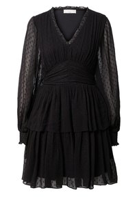 Svart klänning med V-hals, lagerdesign och långa genomskinliga ärmar. Har strukturerad tyg med små prickiga mönster och sammandraget midja.