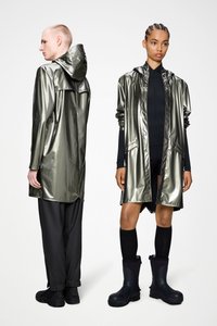 Μεταλλικές πράσινες αδιάβροχες κάπες με κουκούλες, διακοσμημένες με κουμπώματα και πλαϊνές τσέπες. Μαύρο παντελόνι και αδιάβροχα παπούτσια ολοκληρώνουν την εμφάνιση.