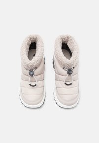 Lyse beige isolerte støvler med en fluffy, kremfarget krage, glatt quiltet overflate, trekkloff og mørk gummisåle for grep.