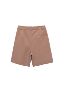 Pantalones cortos marrones a medida con un solo bolsillo trasero de ojal, trabillas para cinturón y un acabado de tela limpio y suave.