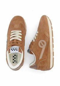 Brown suede sneakers with cream laces, featuring a prominent logo, textured accents, and a sturdy white sole. Interior includes a branded insole.