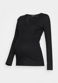Maglietta nera a maniche lunghe con design avvolgente, texture a coste e scollatura a V. Sagomata per una vestibilità aderente, adatta anche per l'abbigliamento premaman.