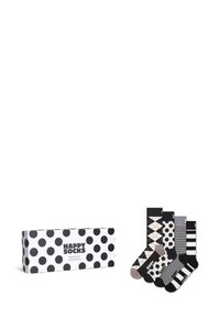 Une boîte-cadeau à pois noir et blanc contenant cinq paires de chaussettes avec des motifs variés : argyle, rayures et designs unis.