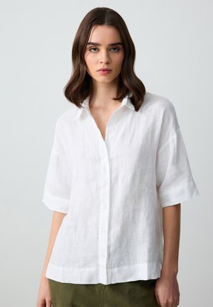 Witte linnen overhemd met korte mouwen, met een knoopsluiting aan de voorkant, een relaxed fit en een klassieke kraag. Gladde textuur met een subtiele glans.